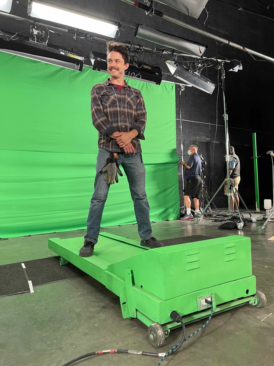 A grip on a green-screen stage during a shoot