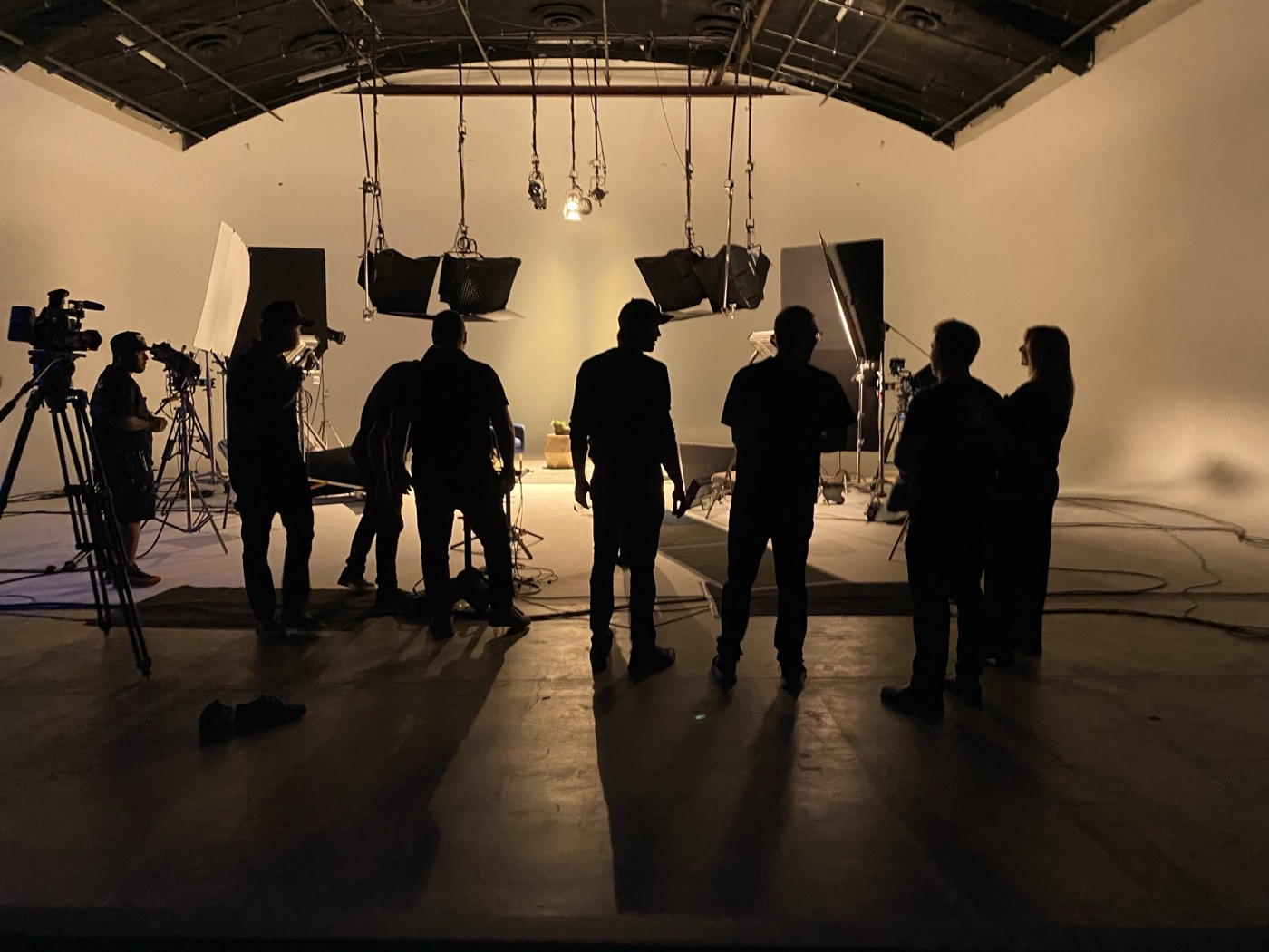 Crew members silhouetted against a lit cyc wall on a Lodger Films stage